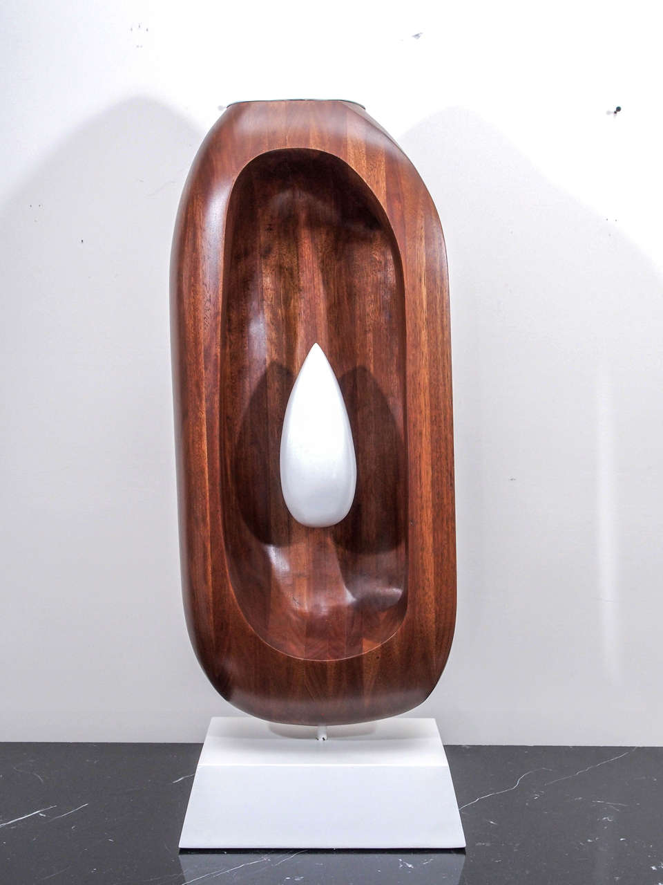 Oval mahogany sculpture with central white teardrop form; white lacquered 